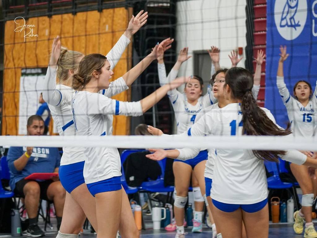Manson volleyball team high fives between matches.