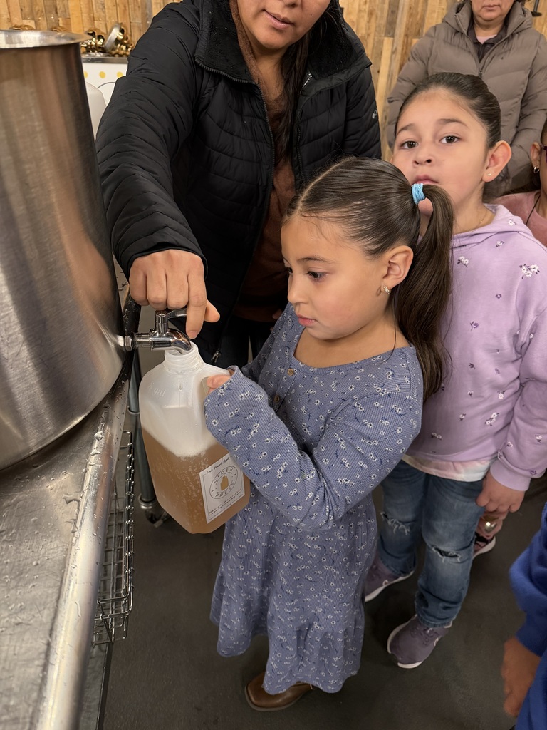 Young girl fills her jug with fresh apple cider.