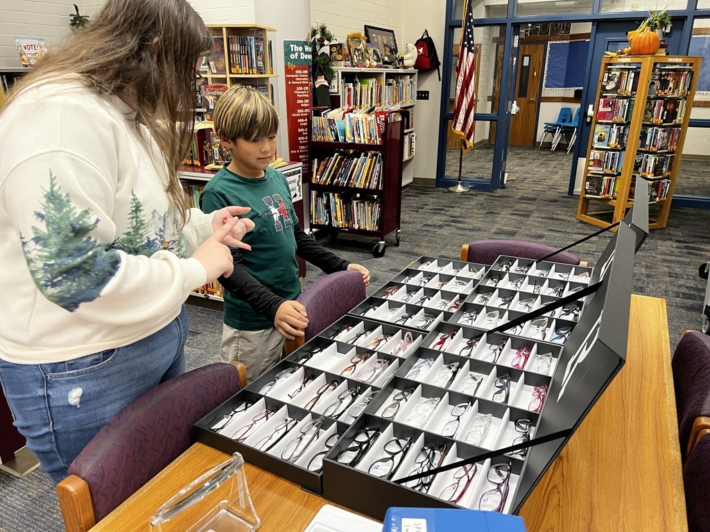 A student looks at an array of glasses with Dr. Pearson's assistant.