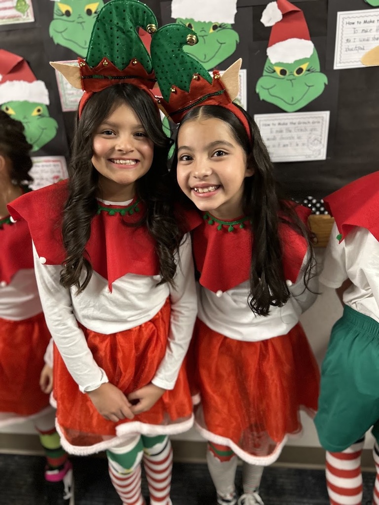 Two cast members posing in elf costumes.