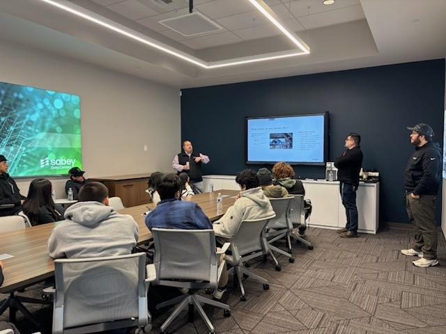 Students in a meeting room listening to a lecture during the Data Center tour.