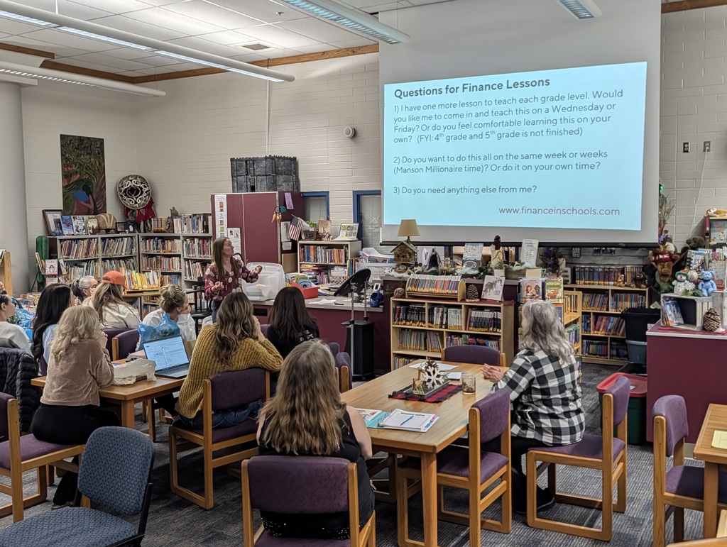 Teachers look at a presentation in the library.
