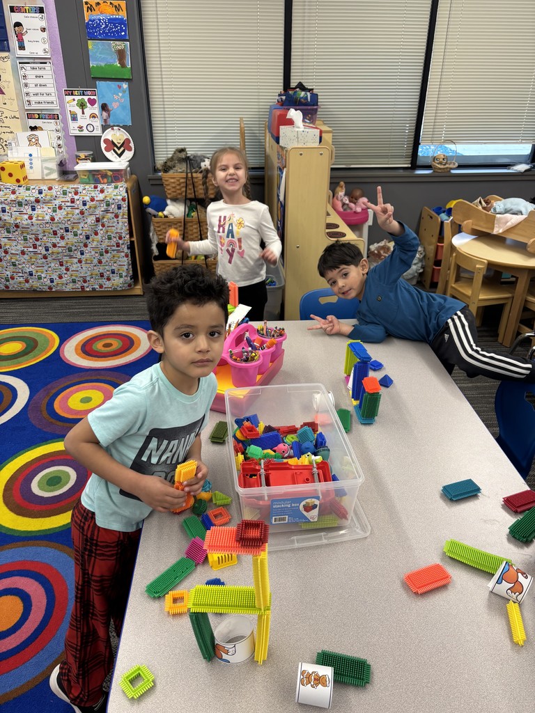 Students stack colored blocks for bridge building.