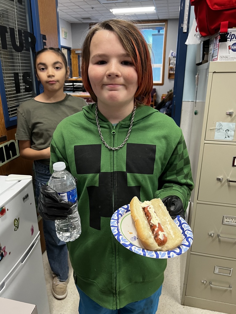 A student serves bottled water and a hot dog