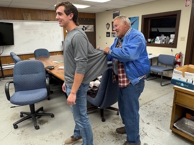 Luke's grandfather cutting Luke's shirt tail, as part of the tradition for soloing
