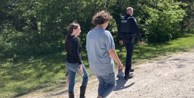 Deputy Wagstaff and a couple of his crew members walking the street in Olivet to find more people in need of assistance.