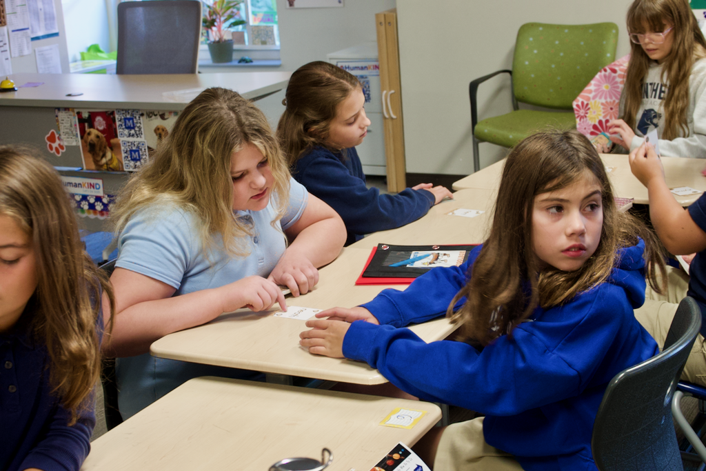 Lower syllables card game - one student is reading the cards and another is looking at the board