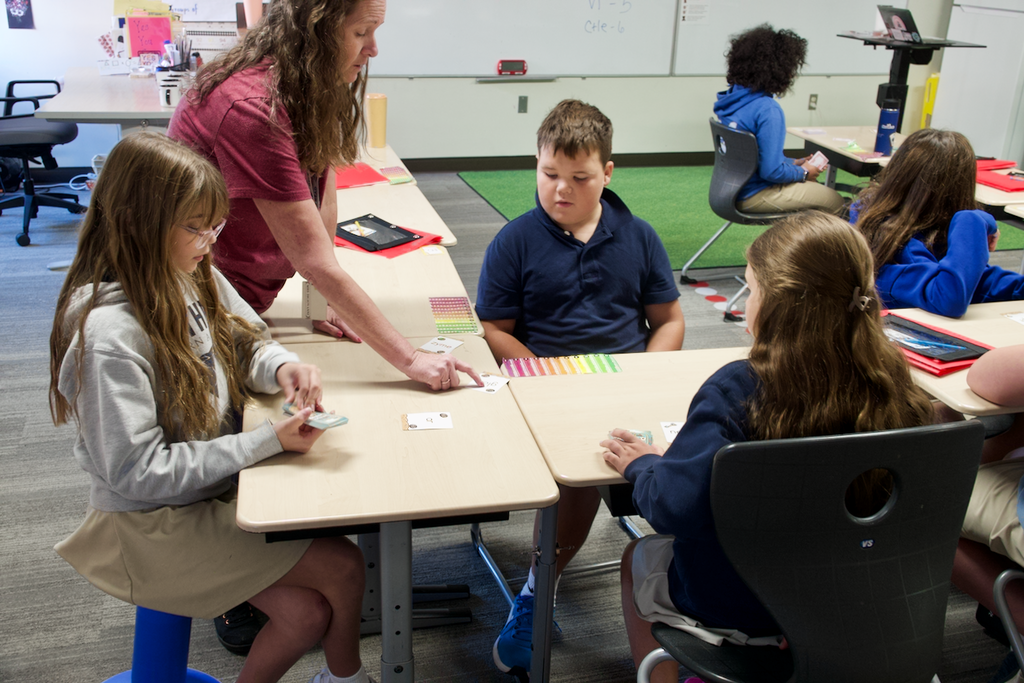 Lower syllables card game - students watching the teacher explain the rules
