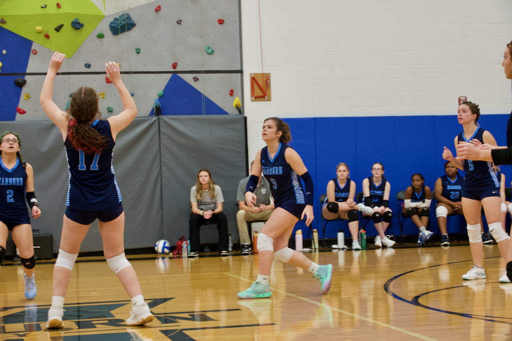 Marburn Volleyball players running towards the ball, one is setting