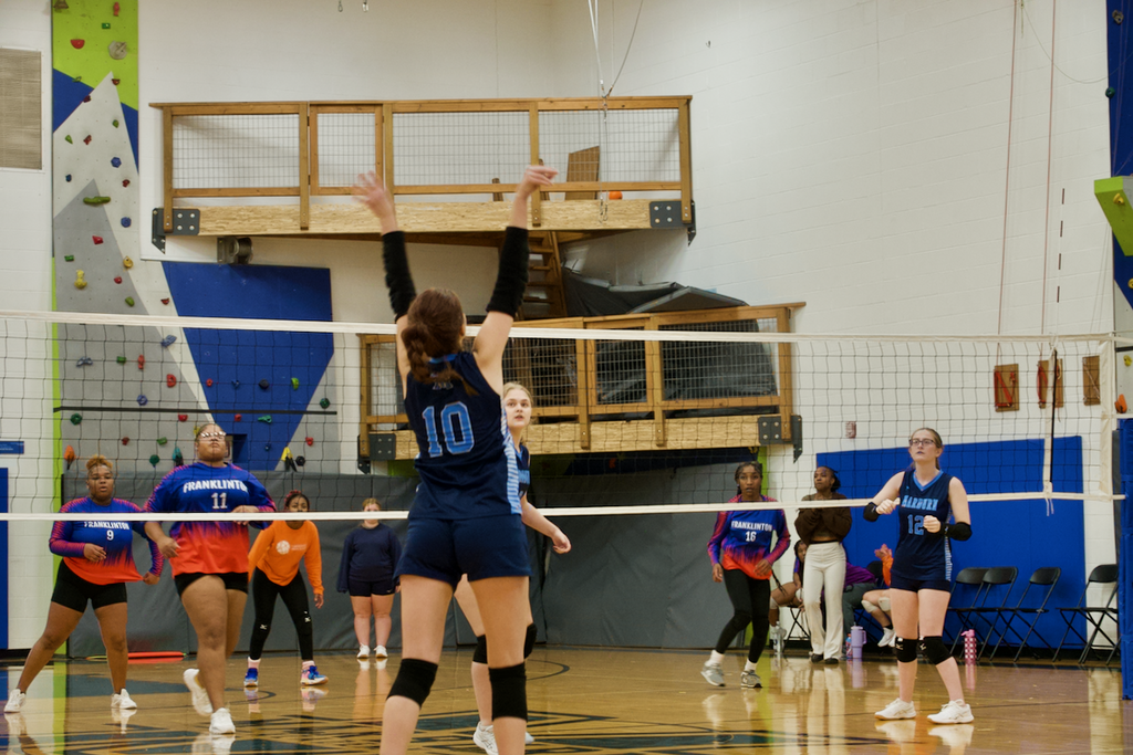 Marburn Volleyball player setting a ball as her teammates look on