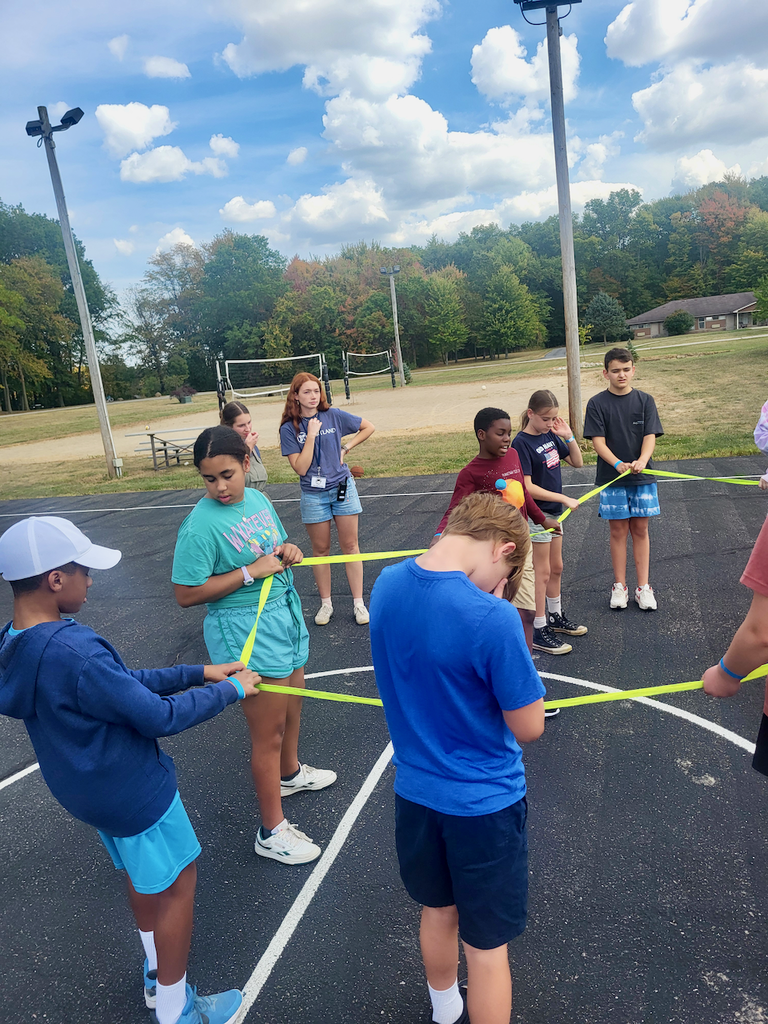 Students doing a team building exercise using a rope