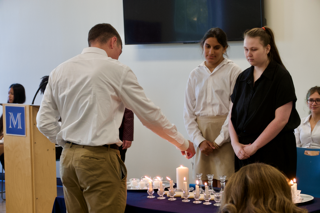 Student lighting candles at NHS induction ceremony