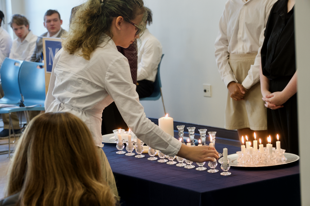 Student lighting candles at NHS induction ceremony