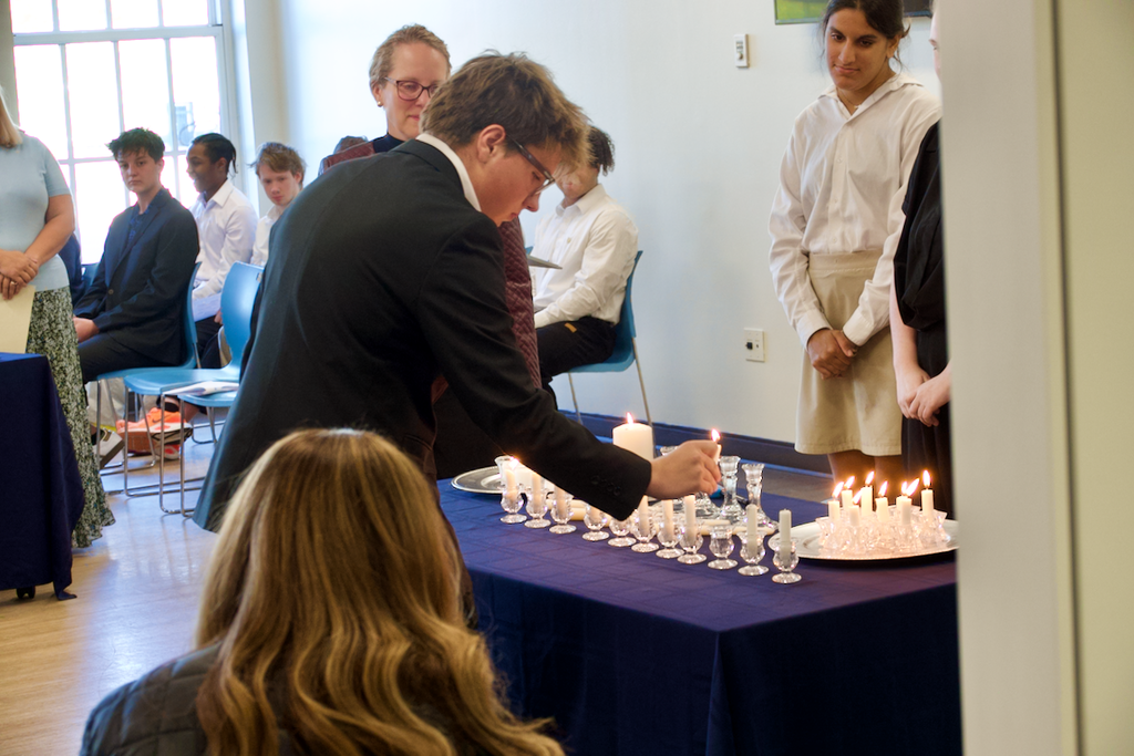 Student lighting candles at NHS induction ceremony