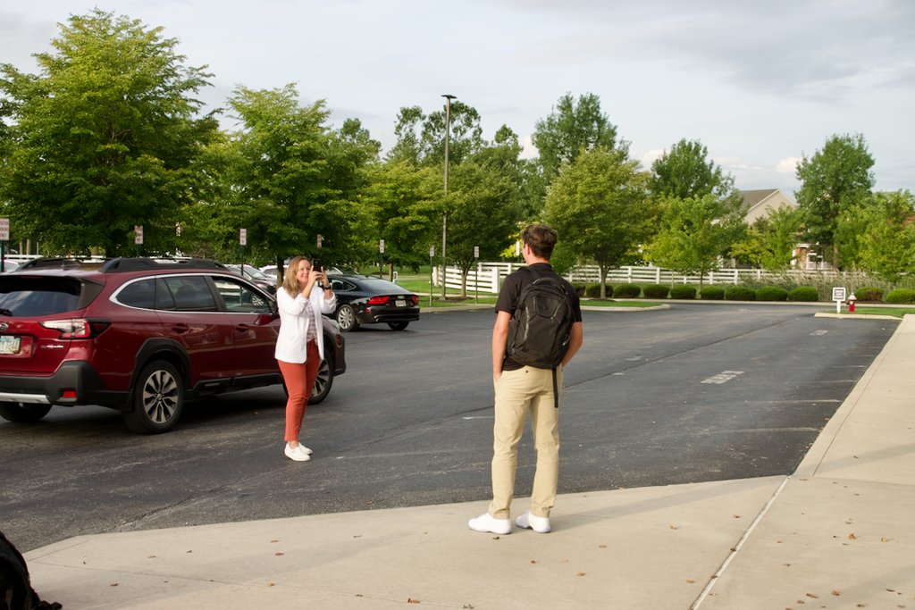 First Day - parent taking a picture of a student outside of school
