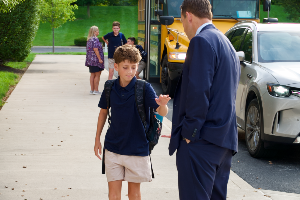 First Day - student high fiving faculty member