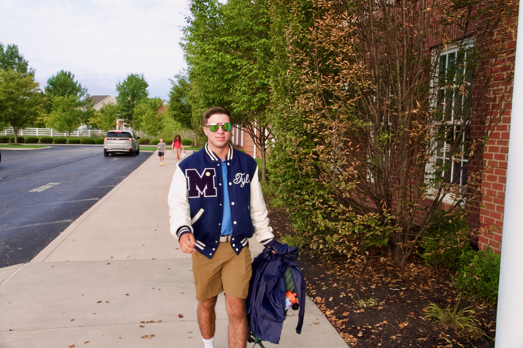First Day - Student walking into school wearing Marburn varsity jacket