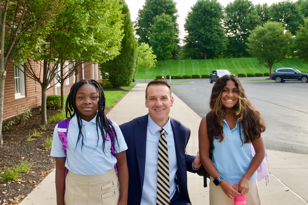 head of school posed with 2 students