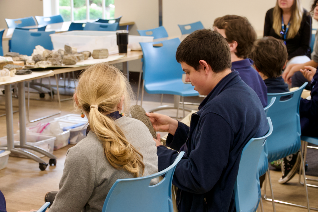 Student smiling looking at a fossil