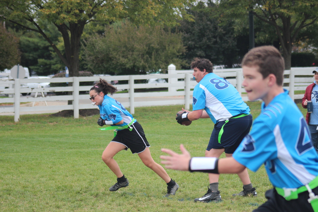 Players running a play during Marburn flag football game.