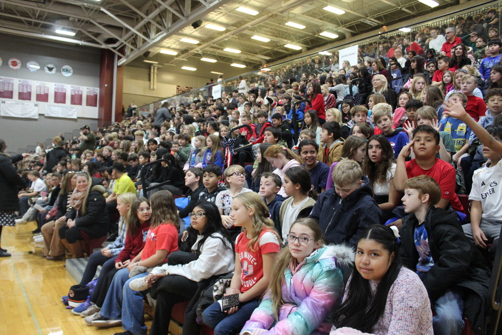 Grant students sitting in bleachers at Veterans day program