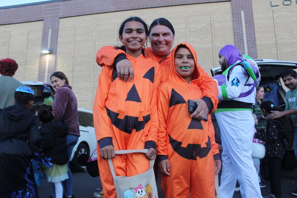 family of three dressed as pumpkins