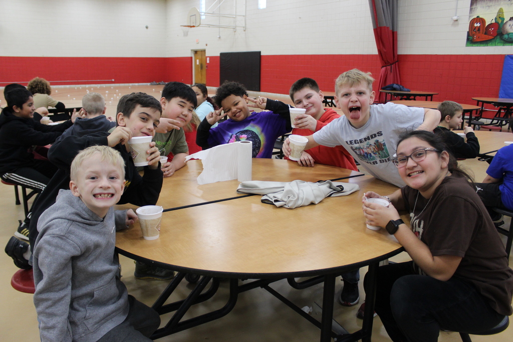 Students drinking hot chocolate at table 