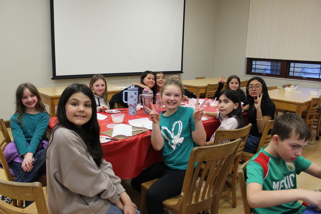 Student group at table decorating cookies 