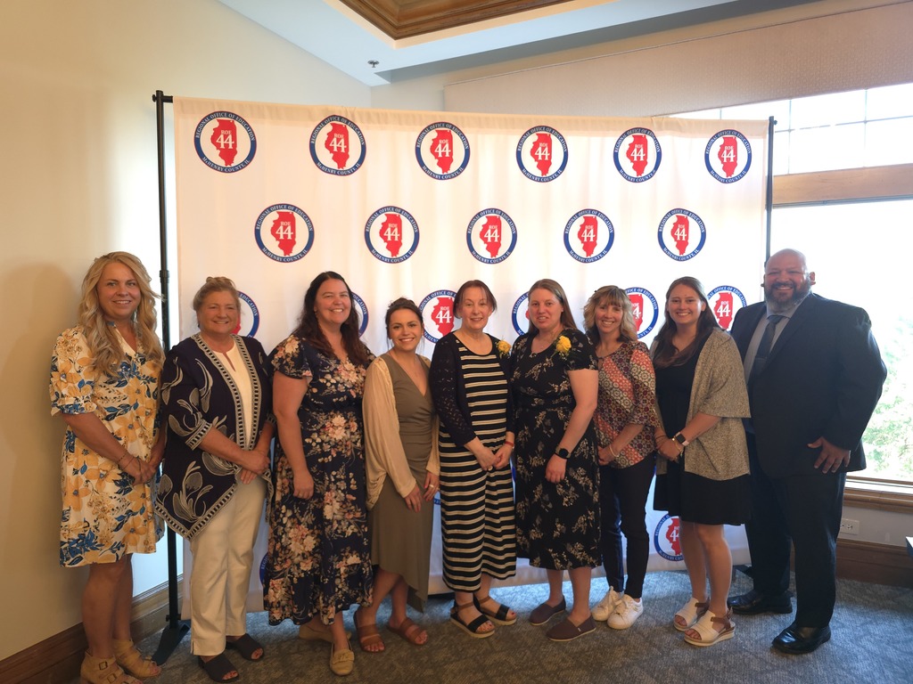 8 staff members standing in front of banner.