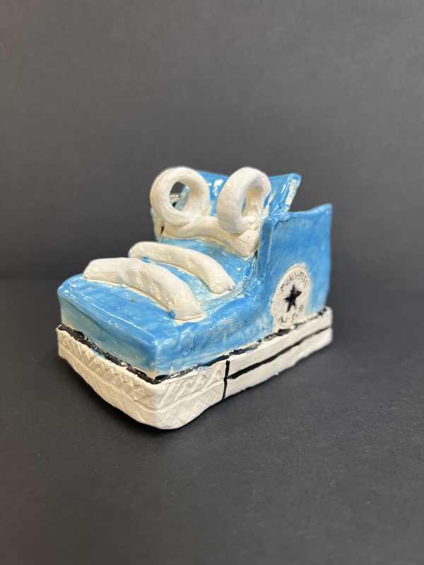 Blue Sneaker Sculpture: A handmade blue sneaker sculpture with white laces and a Converse-style design.