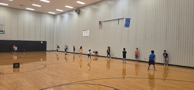 Students in a gym playing catch.