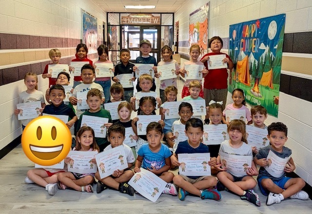 students of the month posing in the hallway with certificates