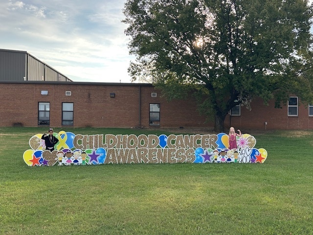 students posing by sign