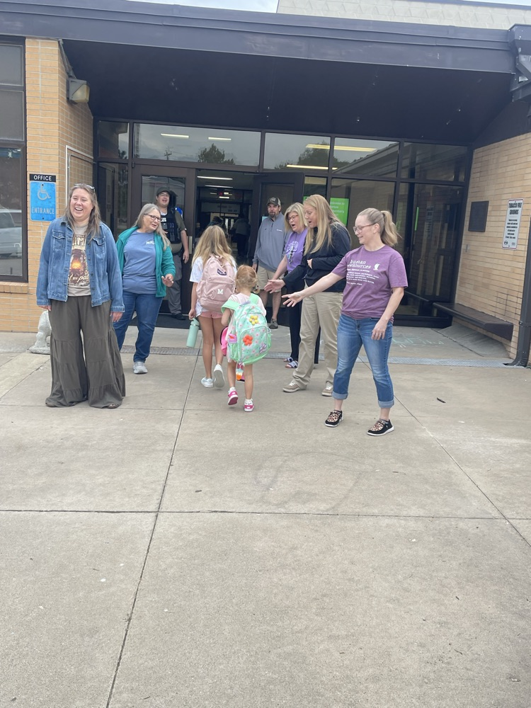 MCSEC staff members giving high fives to a couple elementary students