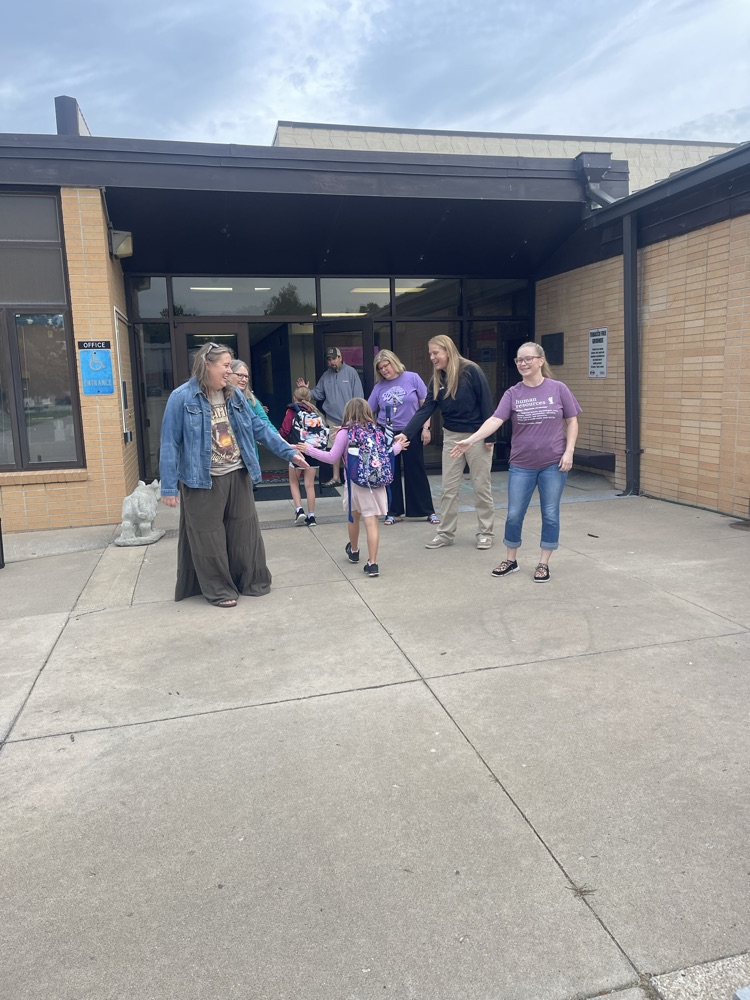 MCSEC staff members greeting a couple MES students as the walk into MES.