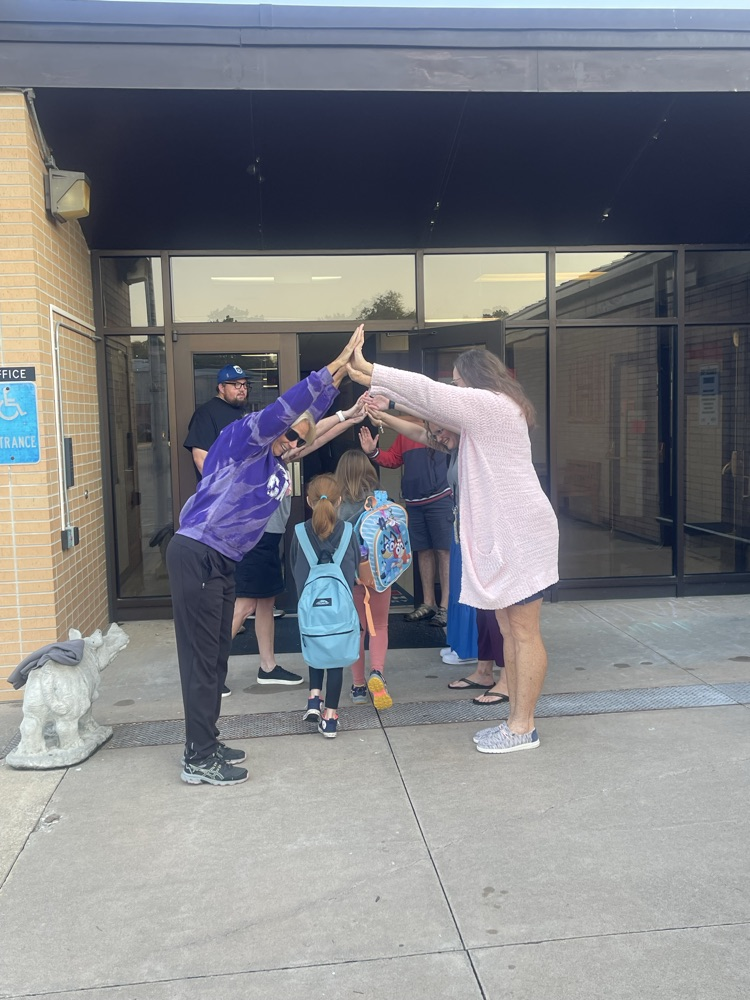 Greeters making a tunnel for students to walk through at MES