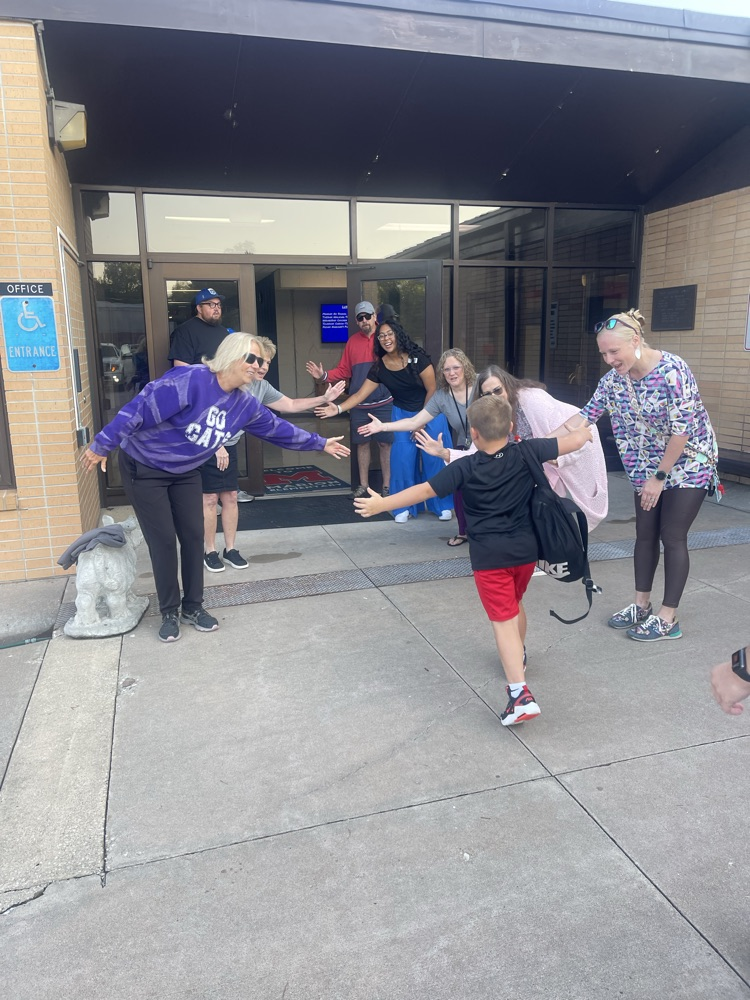 Several MES staff members welcoming a couple of MES students to school