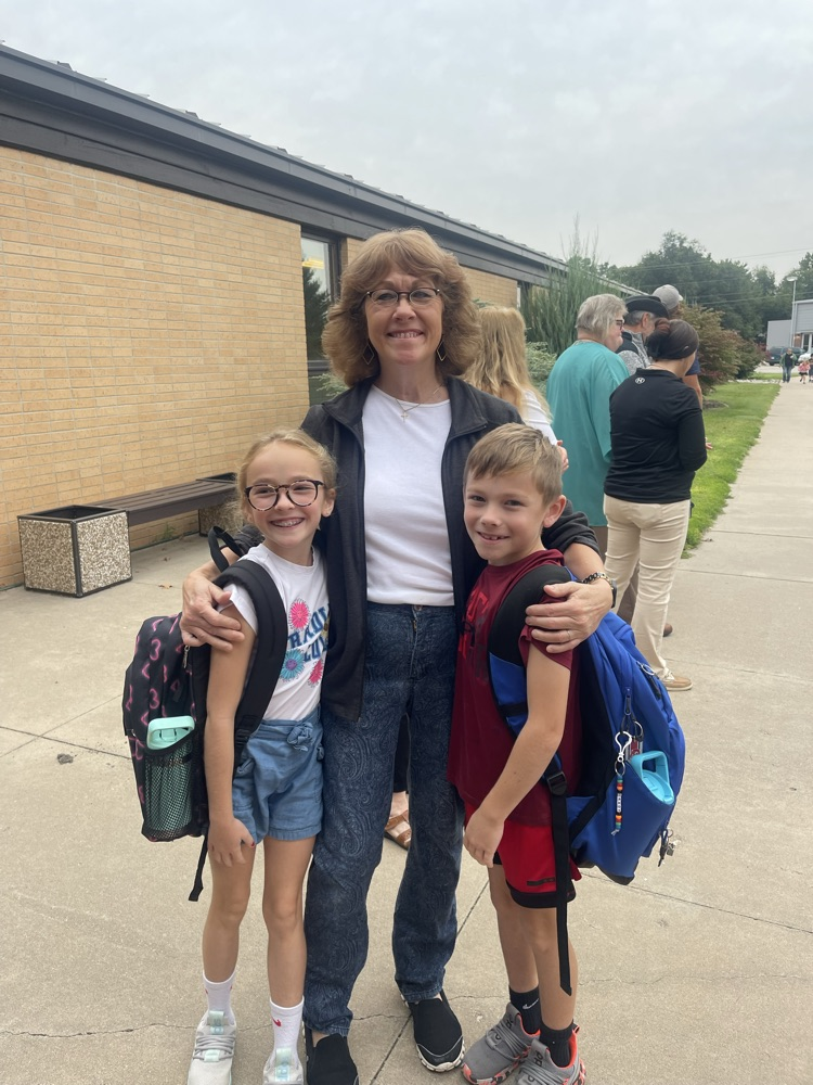 Another grandma greeting students stood to take a picture with her granddaughter and grandson.
