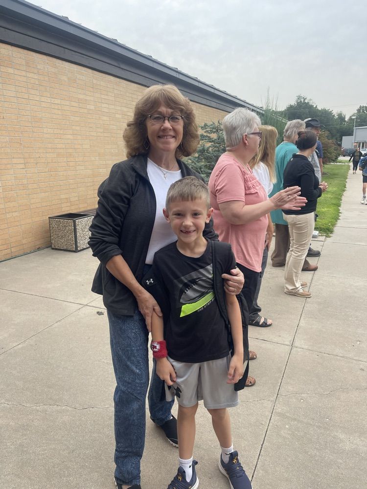Grandma and her grandson outside MES take a picture as she greets students 