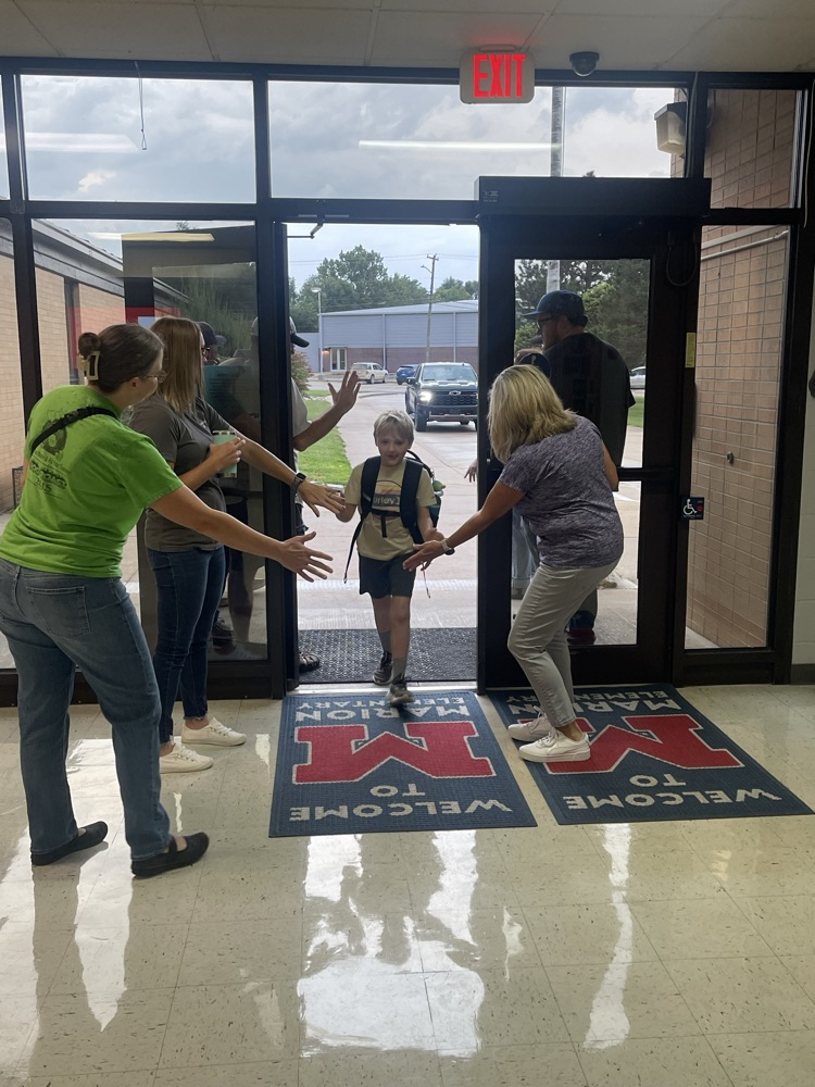Greeters inside the building getting out of the rain