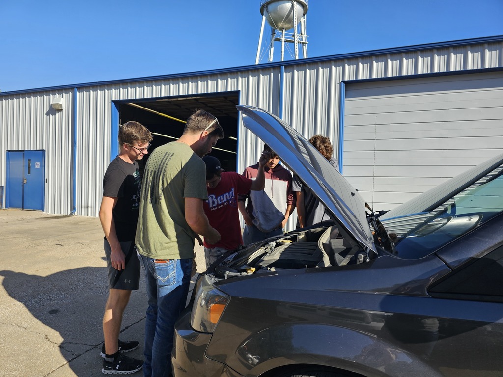 This group of students gets ready to jump start a car.