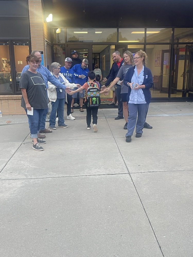 Marion Postal Service employees high five a couple MES students as they walk into the building.