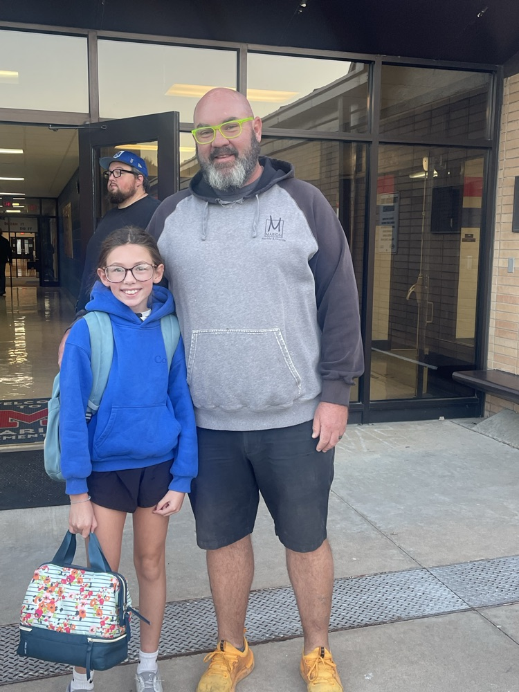A MES student takes a picture with her uncle who was a greeter this morning.