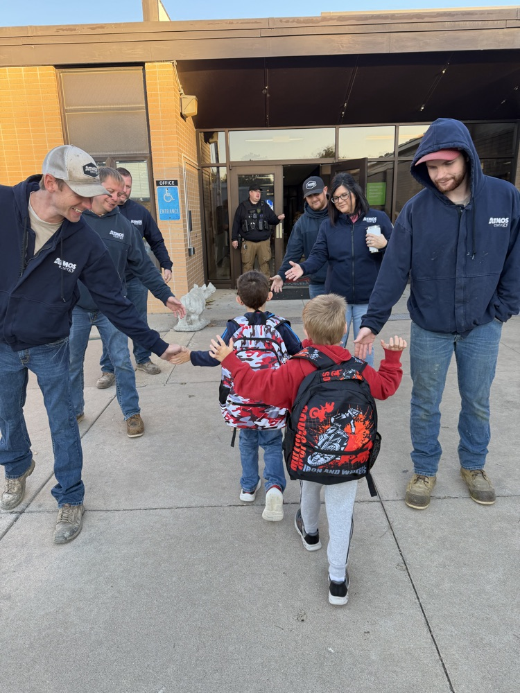 Atmos Energy employees greet students as they enter MES.  