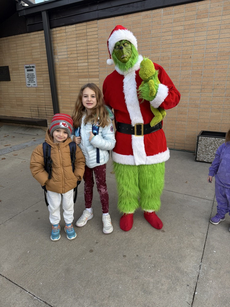 Two students take their picture with The Grinch