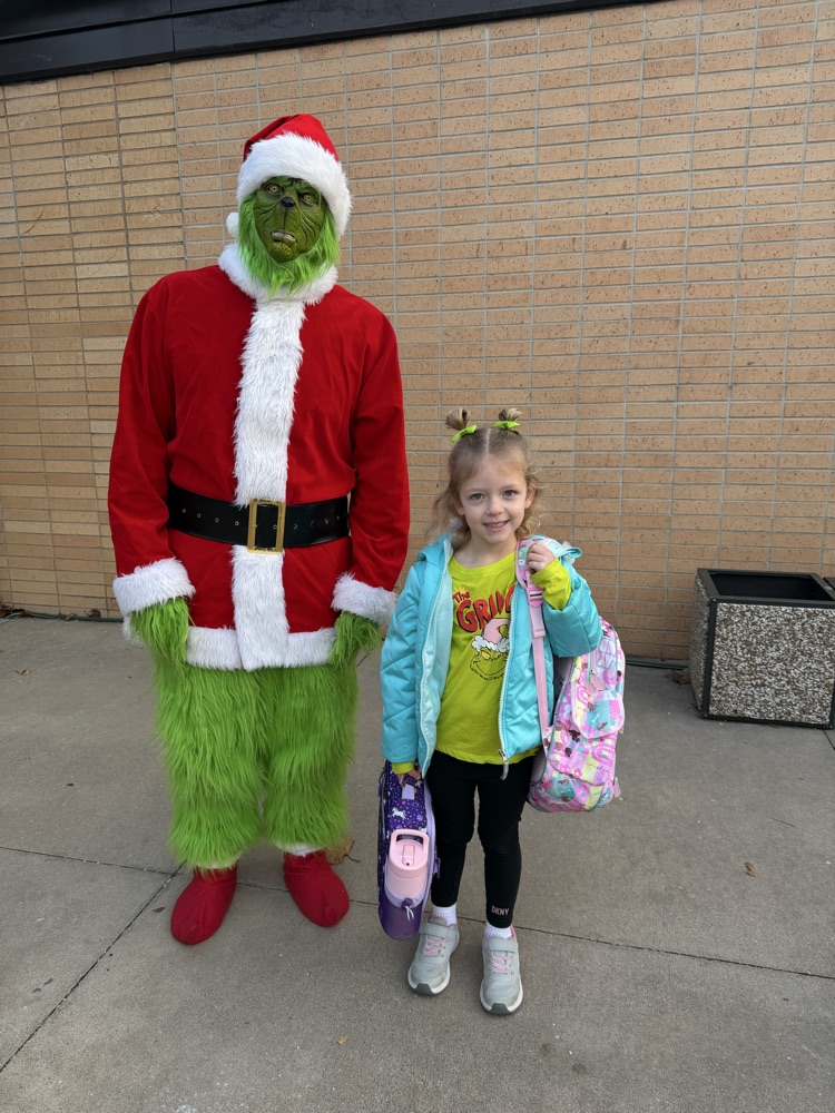 A student takes a picture with the Grinch
