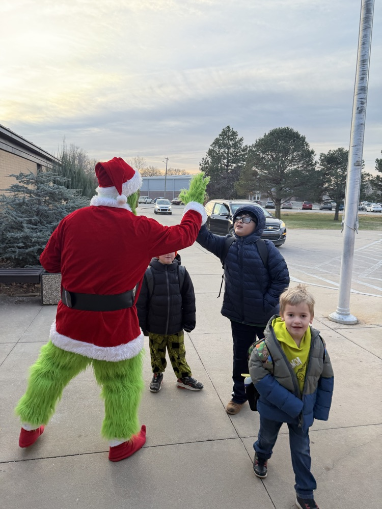 A student gives the Grinch a high five