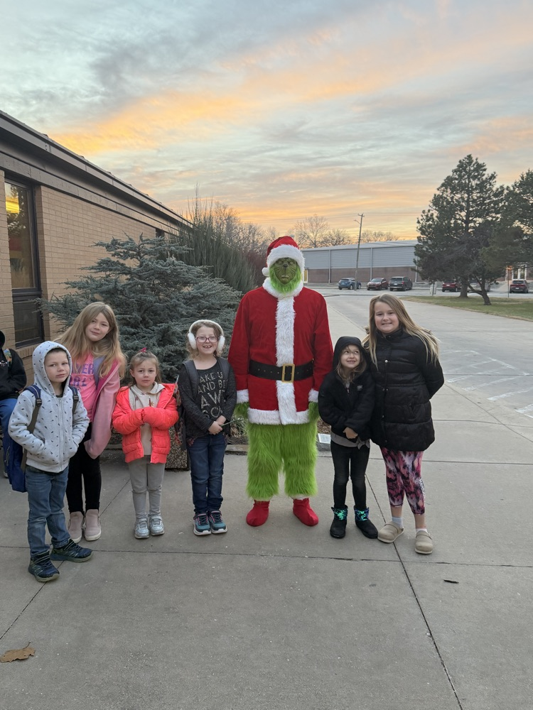 A group of students excited to see the Grinch takes a picture with him