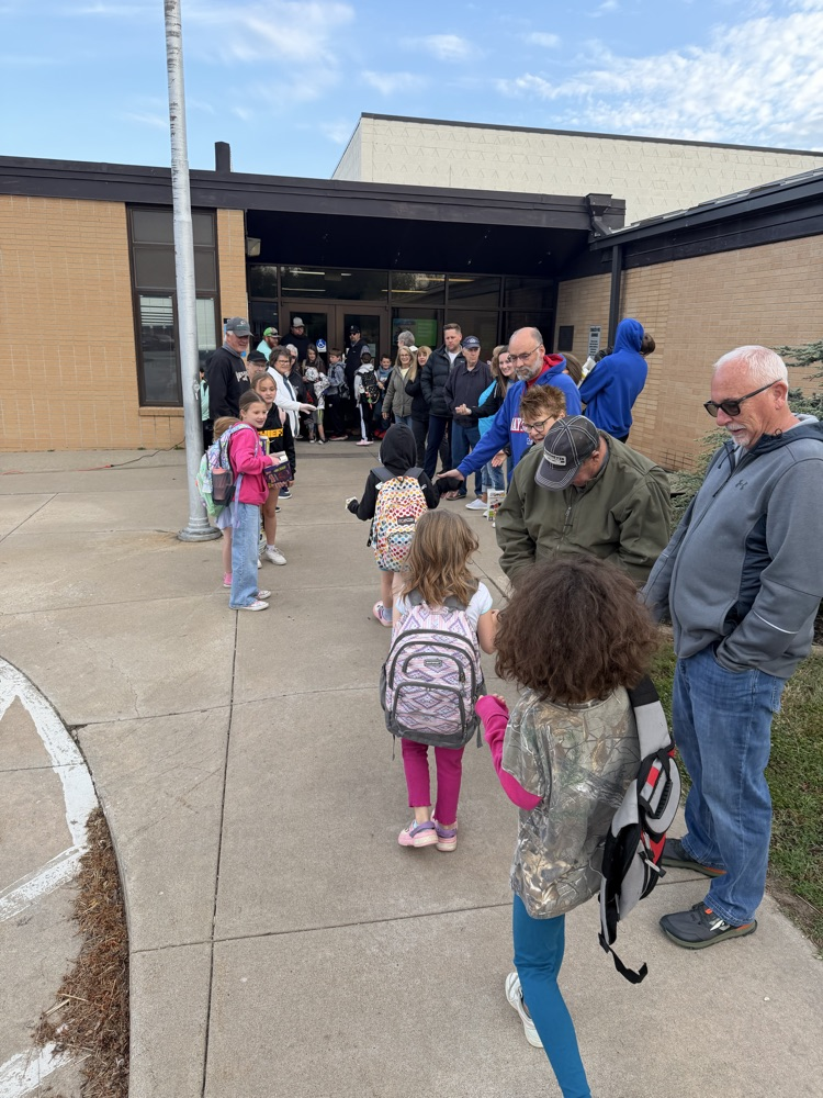 Greeters giving high fives to students