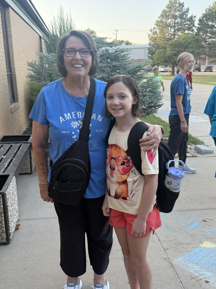 A retired educator gets a hug from her granddaughter